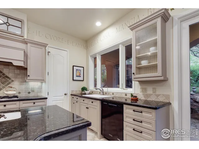 a kitchen with granite countertop a sink and cabinets