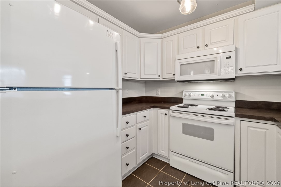 1221 Westview Lane, Unit 301 Raleigh, NC 27605 - Photo 26 of 32 a kitchen with granite countertop white cabinets and white appliances