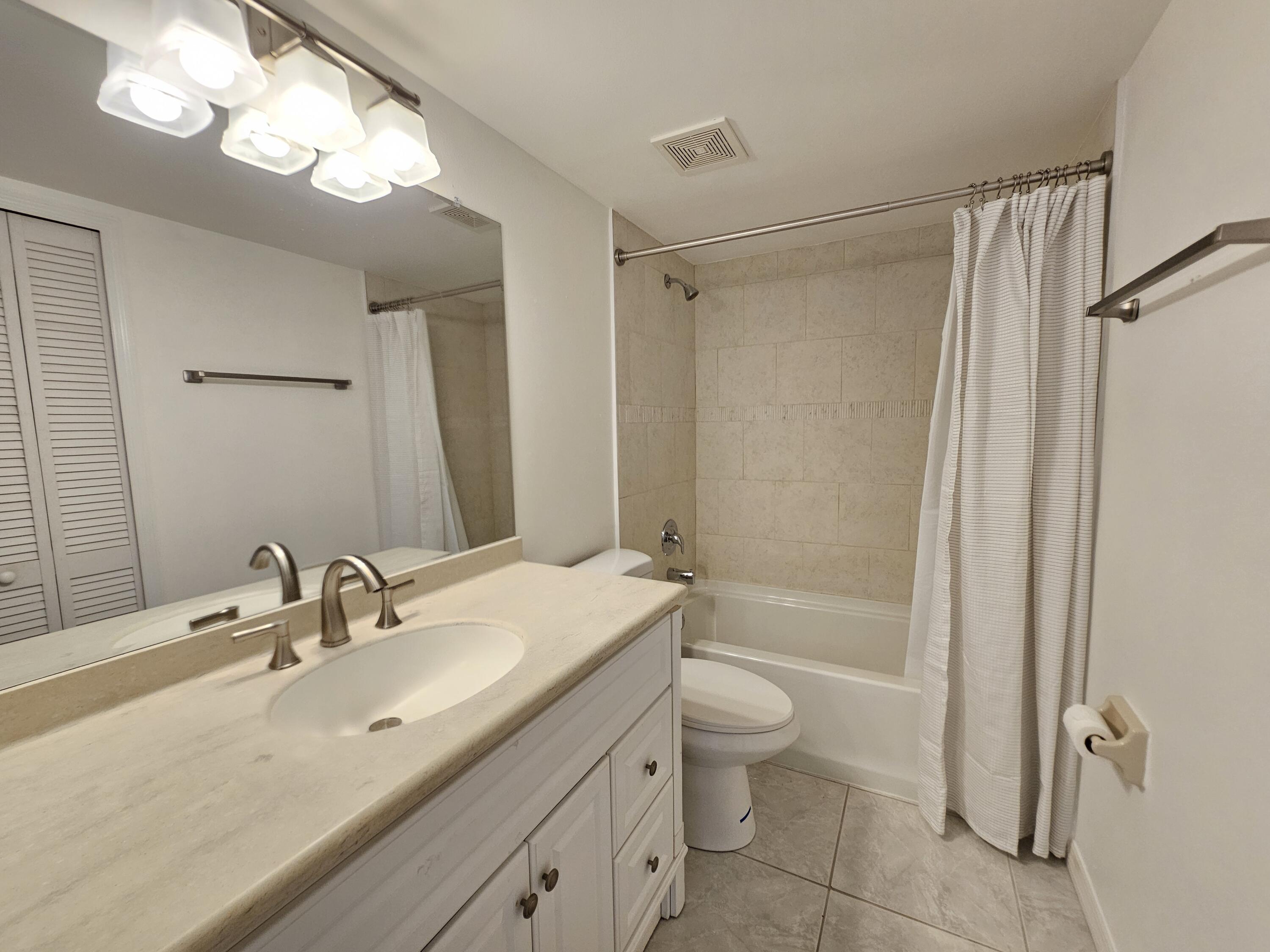 7330 N Highway, Unit 102 Cocoa, FL 32922 - Photo 20 of 26 a bathroom with a granite countertop sink a toilet and shower