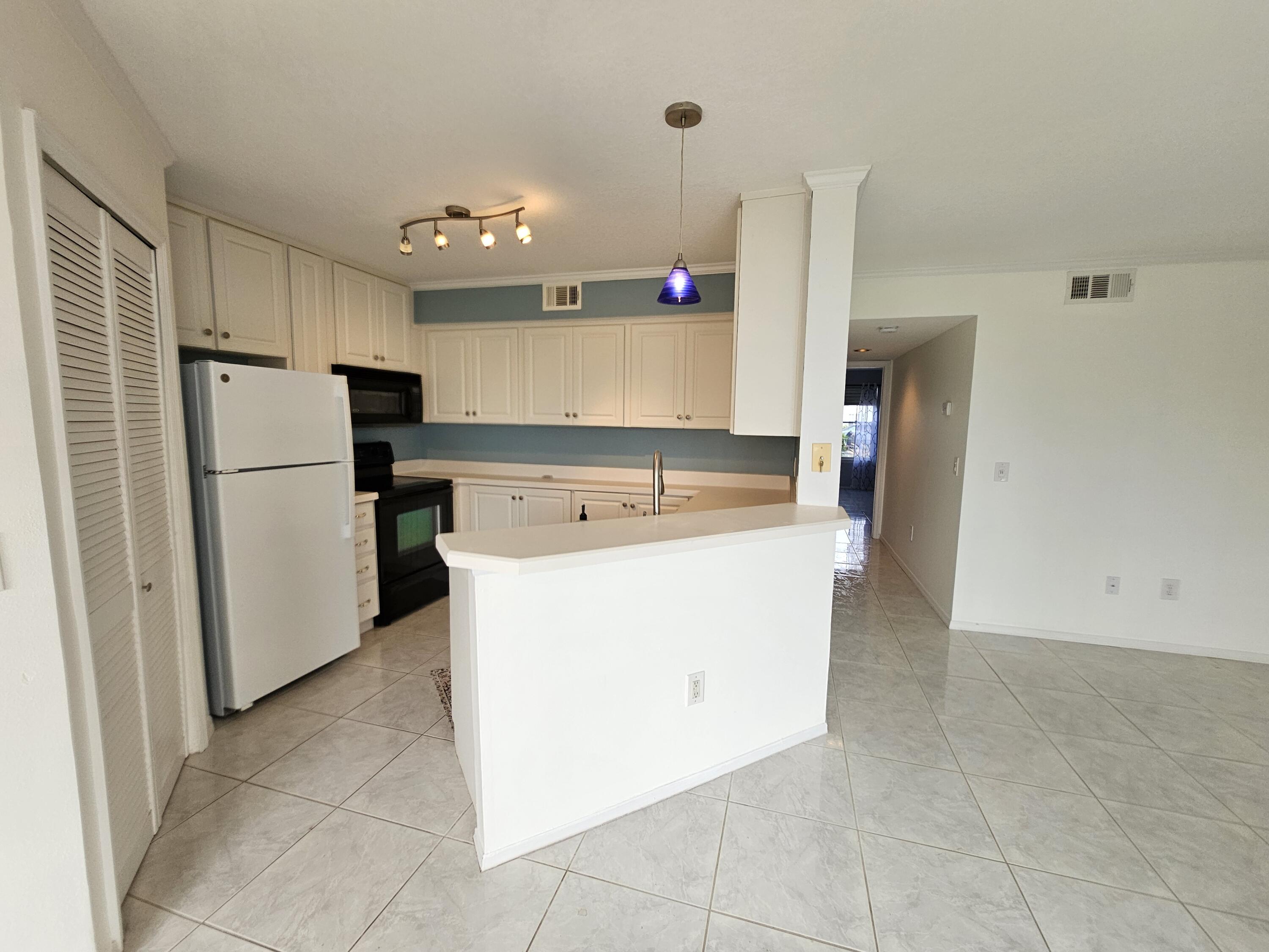 7330 N Highway, Unit 102 Cocoa, FL 32922 - Photo 8 of 26 a kitchen with refrigerator and cabinets
