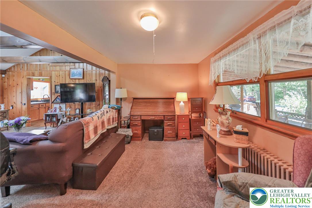 331 Cranberry Creek Road Cresco, PA 18326 - Photo 20 of 95 A well-lit sitting area with soft carpet flooring and an inviting view through multiple large windows.