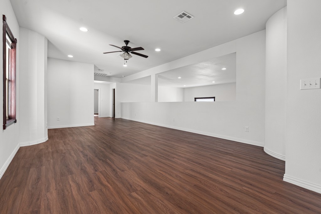 1206 Walter Hoffman Road Cedar Creek, TX 78612 - Photo 25 of 40 an empty room with wooden floor and windows