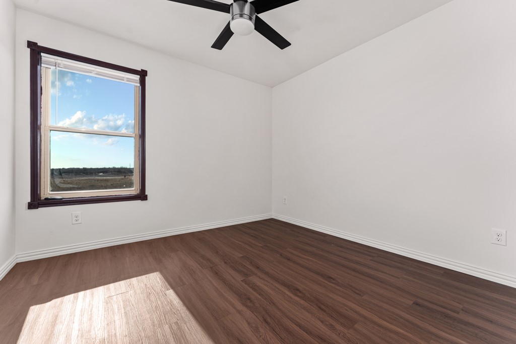 1206 Walter Hoffman Road Cedar Creek, TX 78612 - Photo 28 of 40 a view of an empty room with wooden floor and a window
