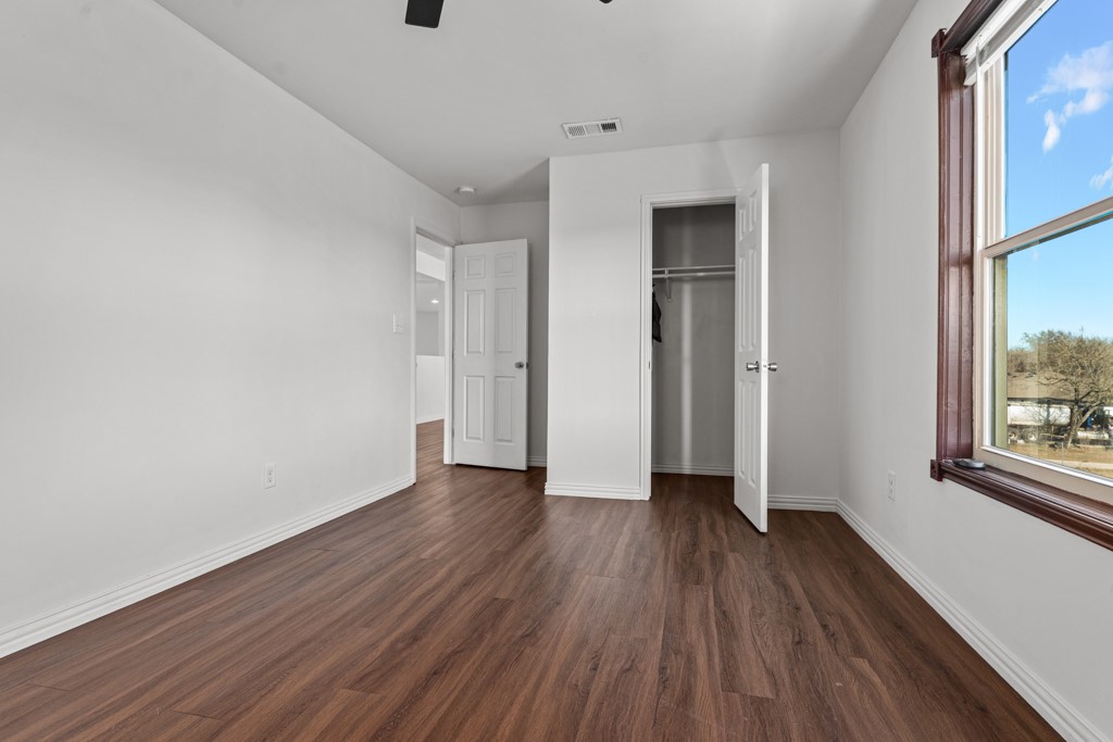 1206 Walter Hoffman Road Cedar Creek, TX 78612 - Photo 29 of 40 a view of an empty room with wooden floor and a window