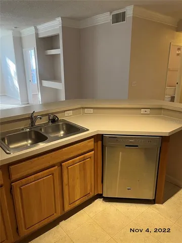a living room with stainless steel appliances a refrigerator sink and microwave