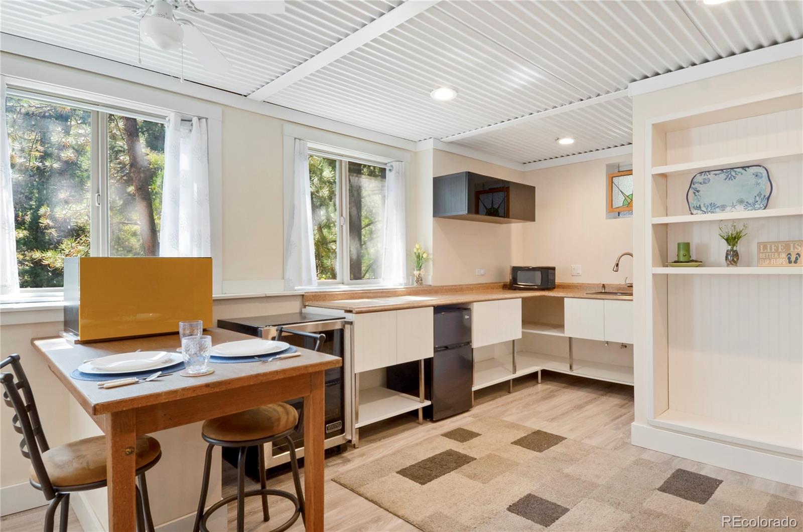 3074 High Road Evergreen, CO 80439 - Photo 30 of 40 a view of a kitchen with kitchen island a dining table and chairs