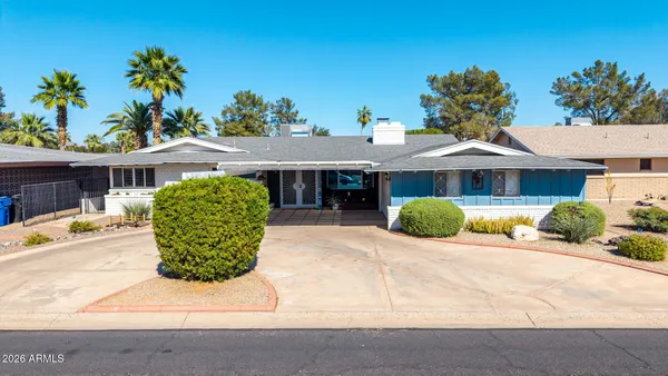 a front view of a house with a yard and potted plants