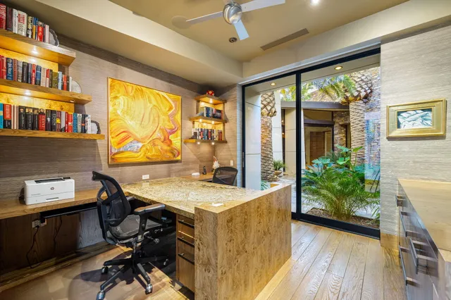 a view of a workspace with furniture and a window