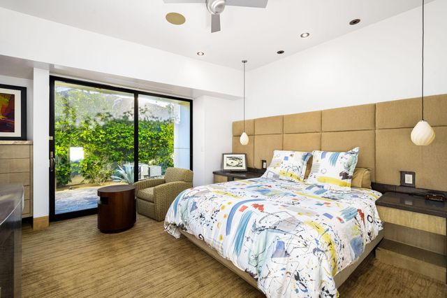 a bedroom with a bed and a large window