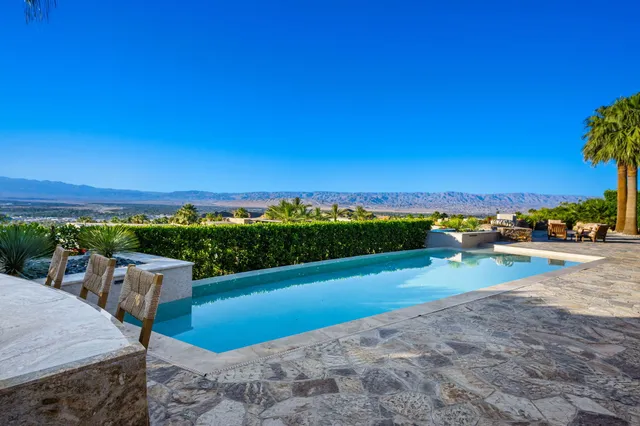 a view of a terrace with a table and chairs under an umbrella