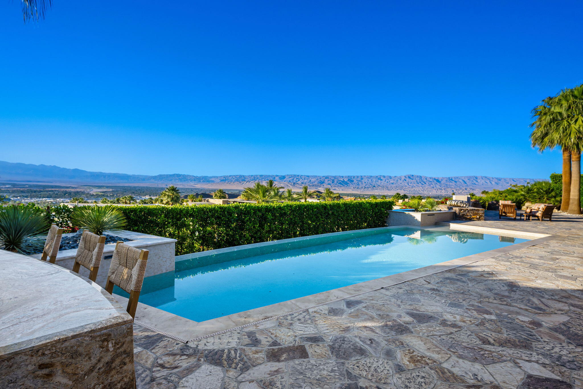 55 Granite Ridge Road Rancho Mirage, CA 92270 - Photo 26 of 34 a view of a terrace with a table and chairs under an umbrella
