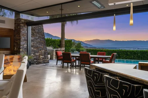 a view of a patio with a dining table and chairs with a flat tv screen