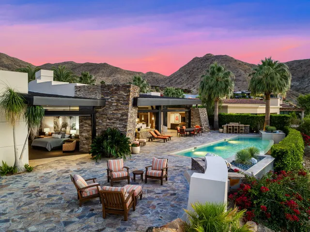 a view of a house with backyard and a sitting area