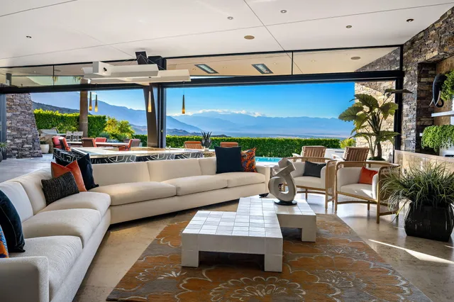 a living room with patio furniture and a fireplace