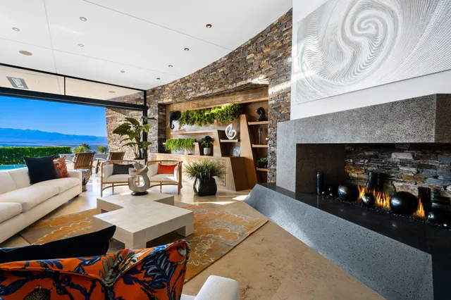 a living room with furniture a fireplace a rug and a window