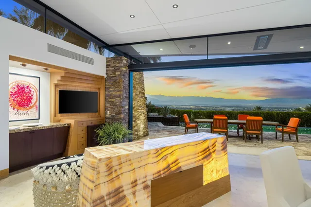 a living room with patio furniture and a flat screen tv