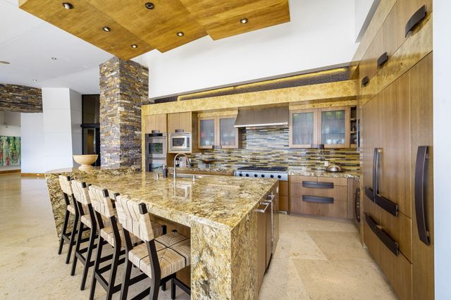 a kitchen with cabinets and chairs