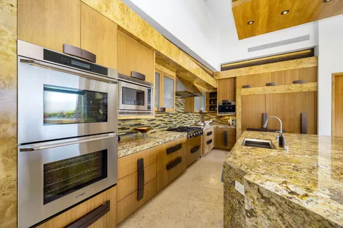 a kitchen with stainless steel appliances granite countertop a stove a sink and a microwave