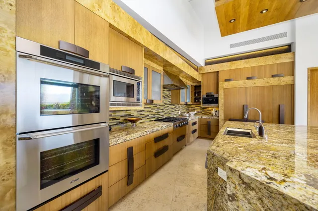 a kitchen with stainless steel appliances granite countertop a stove a sink and a microwave