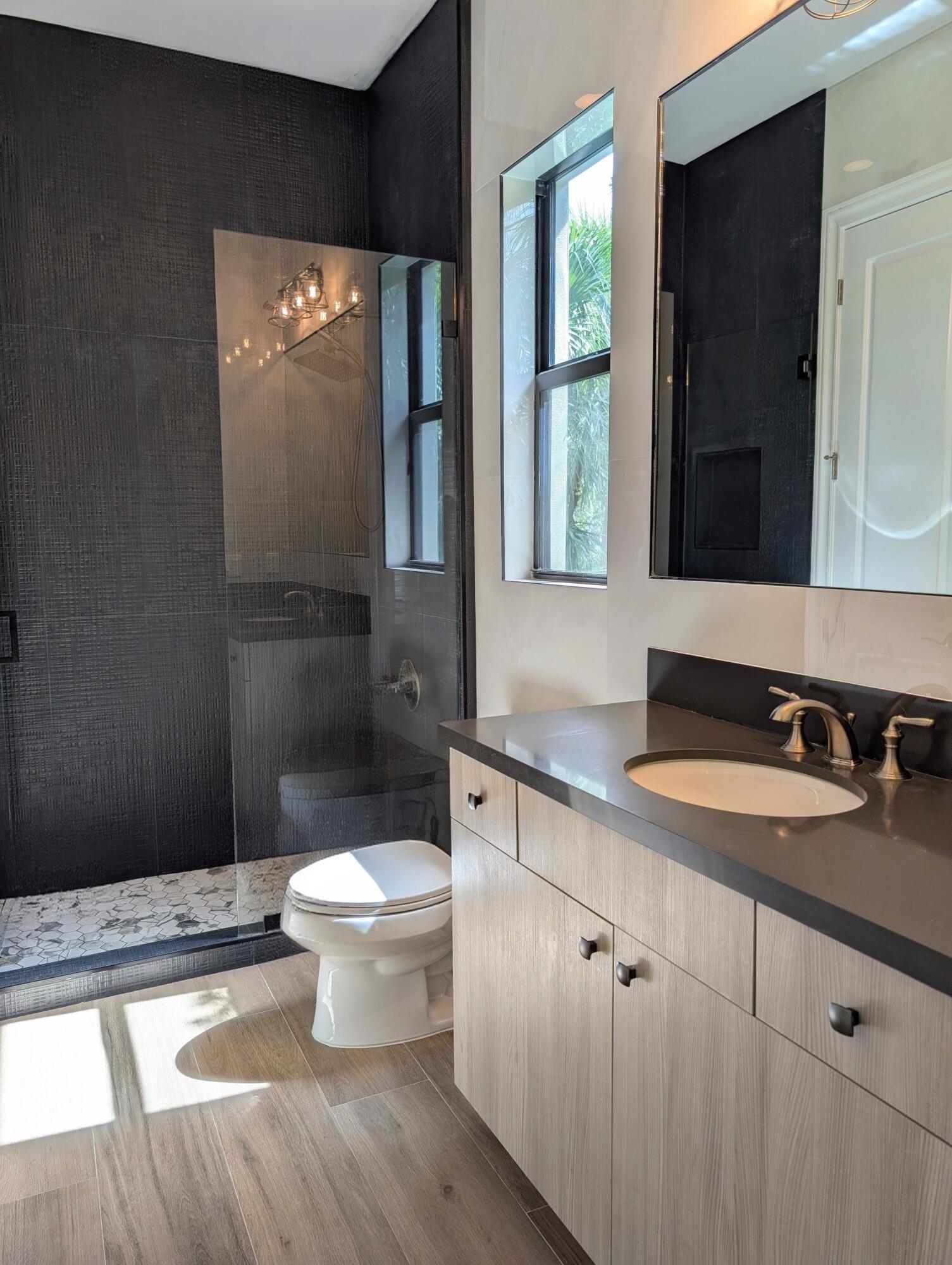 7095 Northwest 27th Avenue Boca Raton, FL 33496 - Photo 27 of 51 a bathroom with a toilet sink and mirror