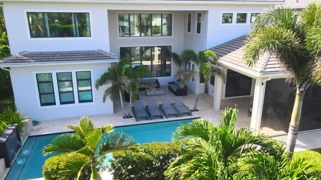 a view of a swimming pool with a patio and plants