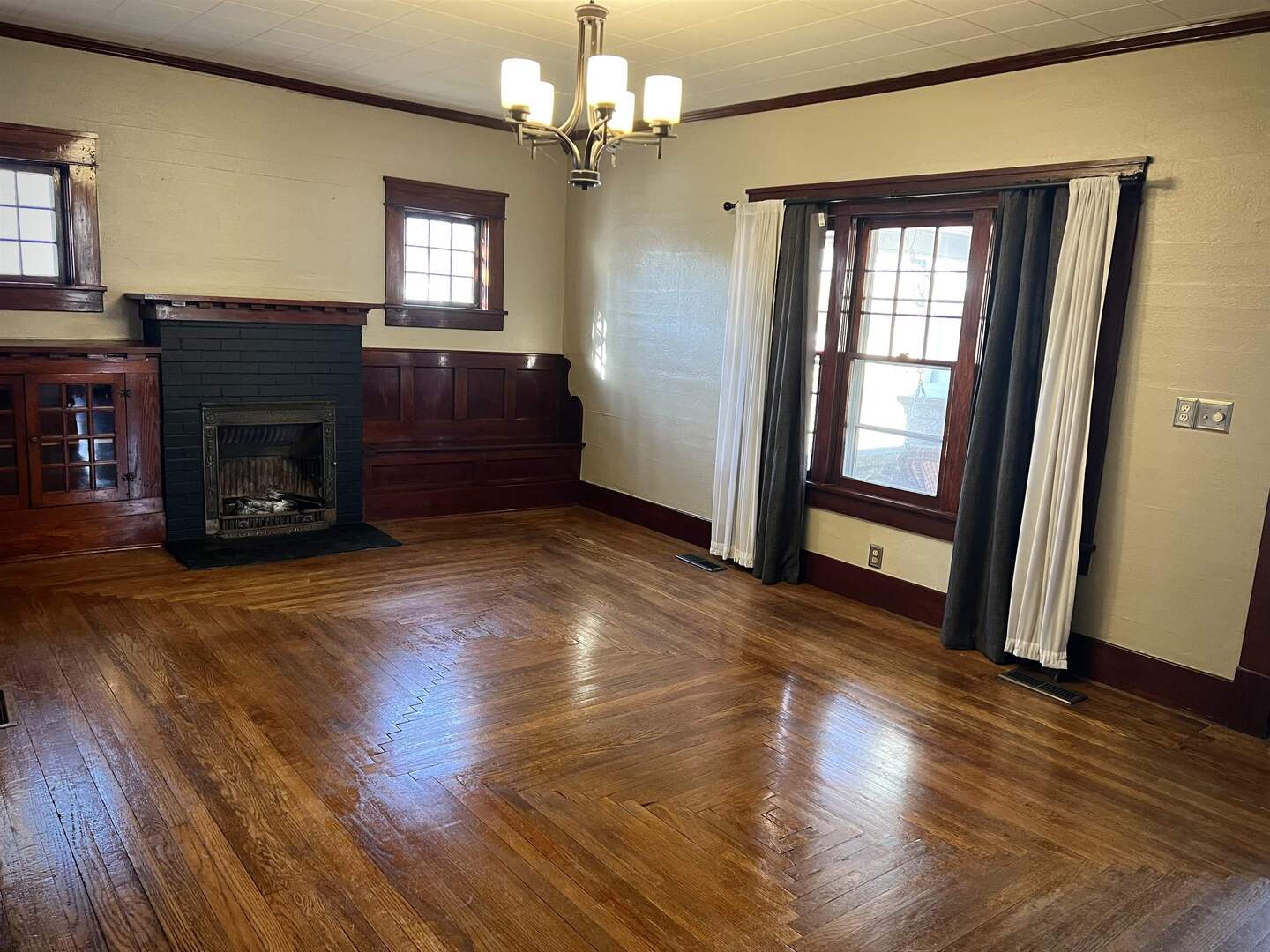 505 California Street Carterville, IL 62918 - Photo 13 of 23 an empty room with wooden floor fireplace and windows