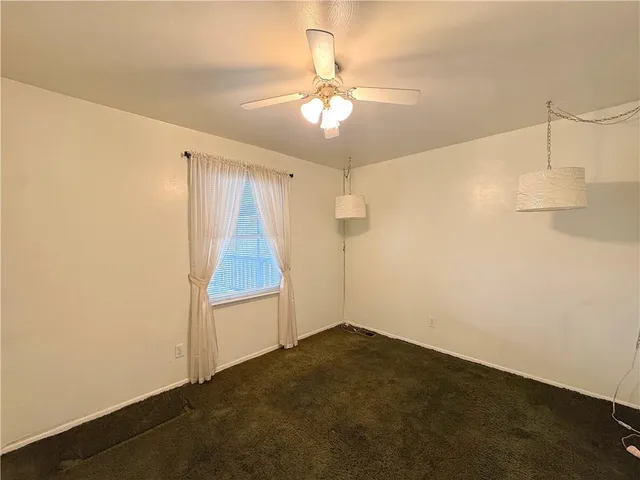 an empty room with a ceiling fan and a window