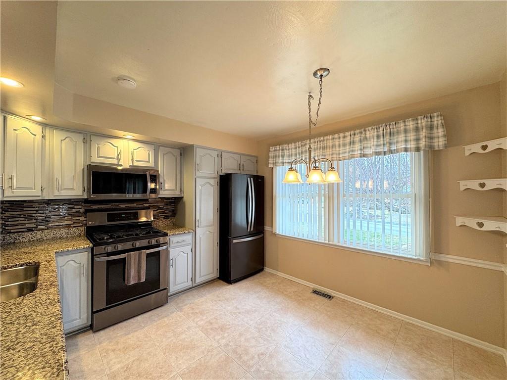 111 Mt Pleasant Boulevard Irwin, PA 15642 - Photo 9 of 27 a kitchen with stainless steel appliances granite countertop a refrigerator a stove a sink and a microwave