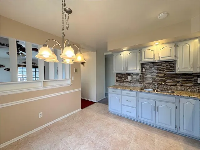 a spacious bathroom with a granite countertop sink mirror and a bathtub