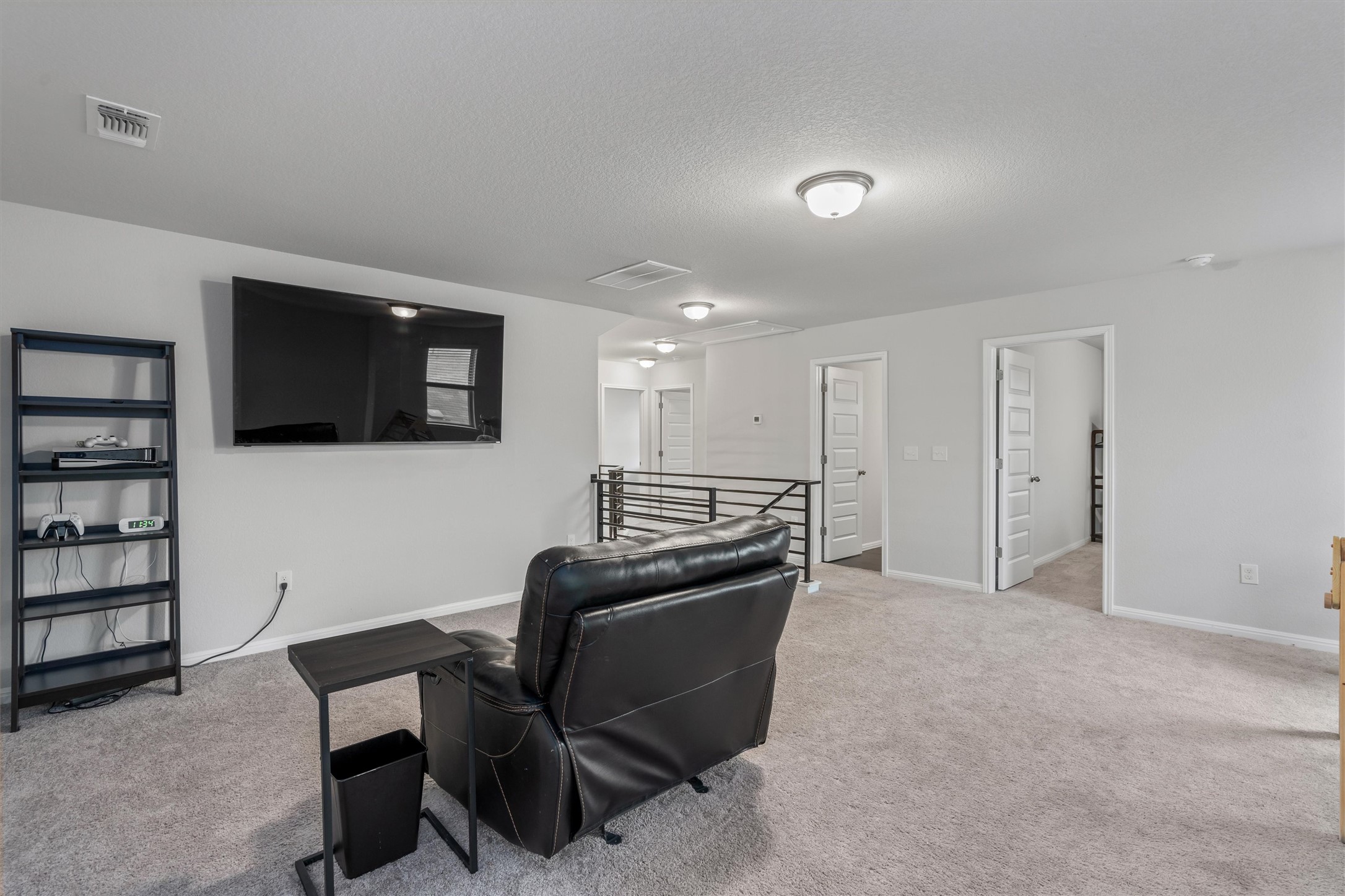224 Backstays Loop Kyle, TX 78640 - Photo 12 of 19 Expansive upper-level space featuring light gray carpeting, neutral wall finishes, flush-mount ceiling lighting, and a black metal railing system