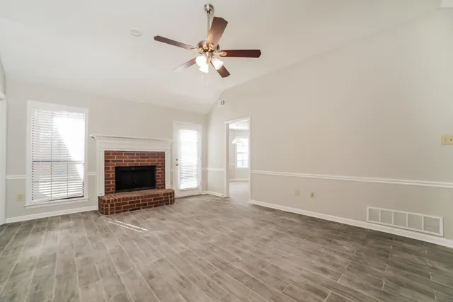 an empty room with fireplace and wooden floor