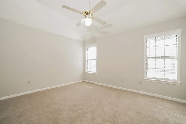 an empty room with a window and a fan