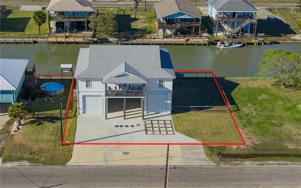 an aerial view of a house with swimming pool and outdoor seating