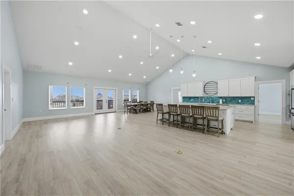 a kitchen with stainless steel appliances kitchen island granite countertop a table chairs sink and cabinets