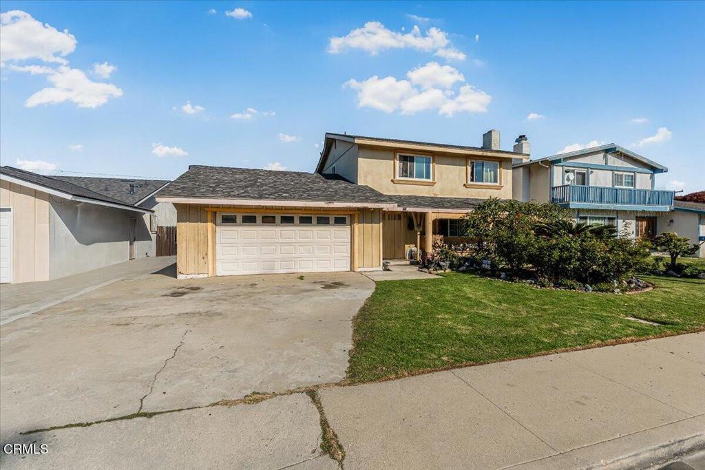 1211 West Robert Avenue Oxnard, CA 93030 - Photo 1 of 14 a front view of a house with a yard and garage