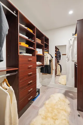 a view of walk in closet with clothes and shoes