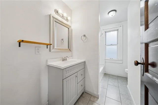 a bathroom with a sink a toilet and mirror