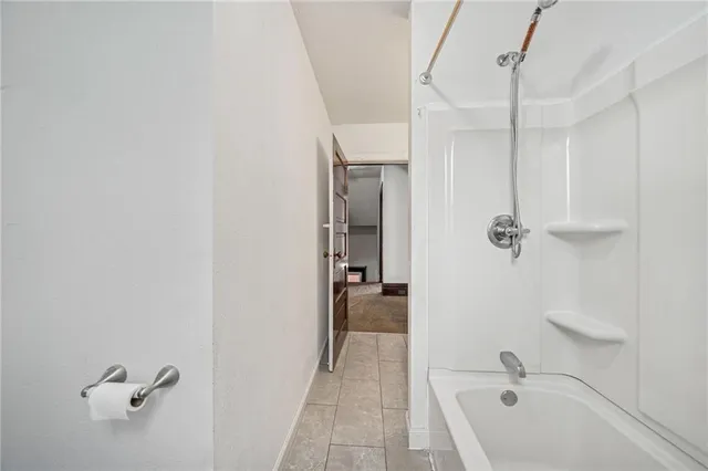 a bathroom with a tub a sink and mirror