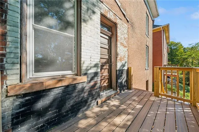 a view of a porch with wooden floor and a yard