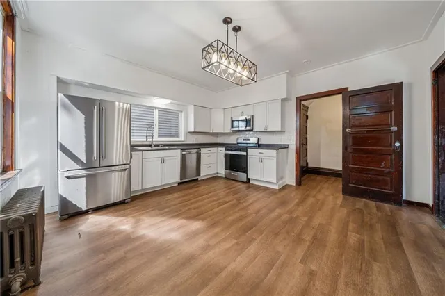 a kitchen with stainless steel appliances granite countertop a refrigerator and a stove top oven