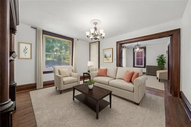 a living room with furniture a chandelier and a large window