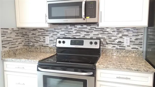 a stove top oven sitting inside of a kitchen