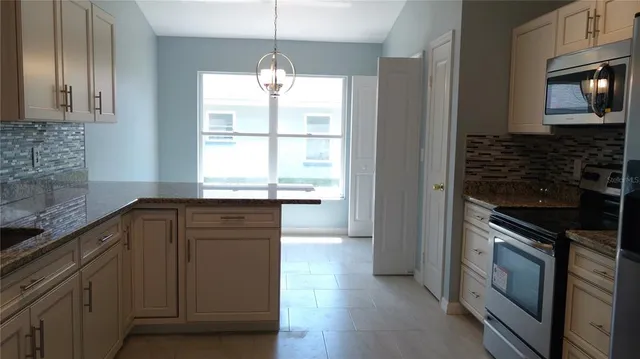 a kitchen with granite countertop wooden cabinets and a stove top oven