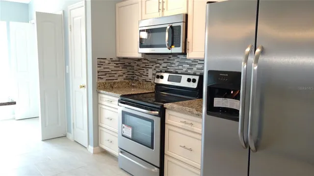 a kitchen with stainless steel appliances granite countertop a stove and a refrigerator