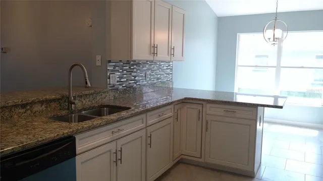 a kitchen with granite countertop a sink and a window