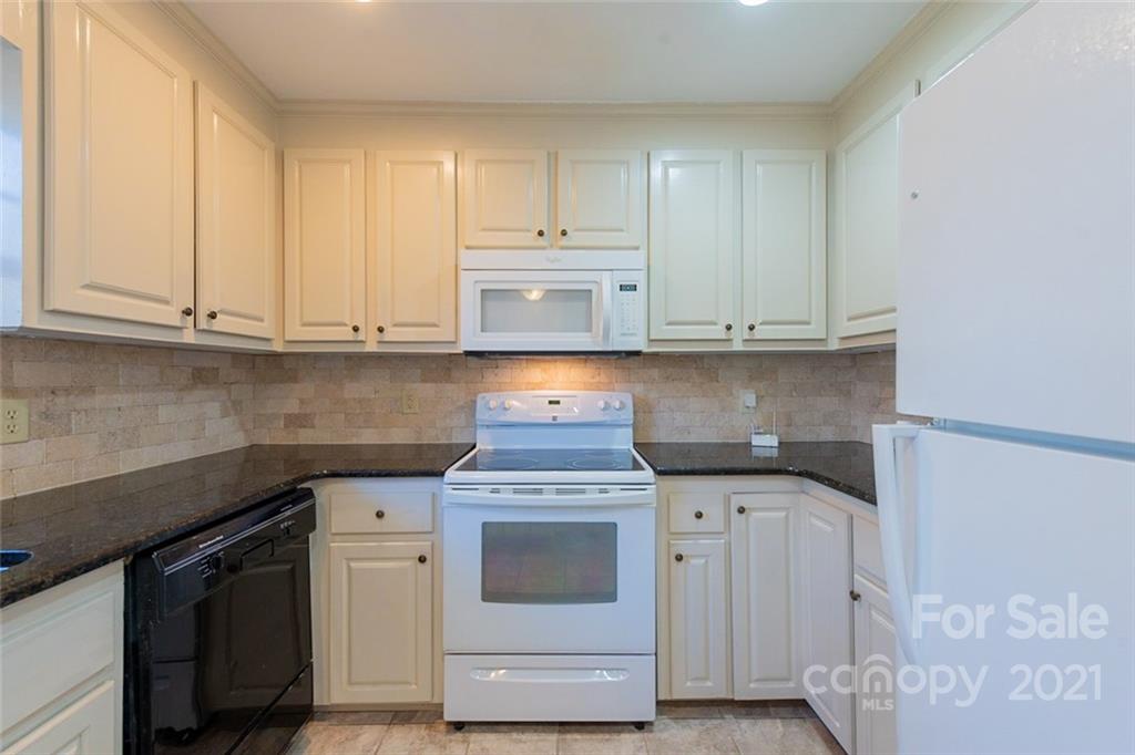 1593 Brook Drive Fort Mill, SC 29708 - Photo 4 of 18 a kitchen with granite countertop white cabinets and white appliances