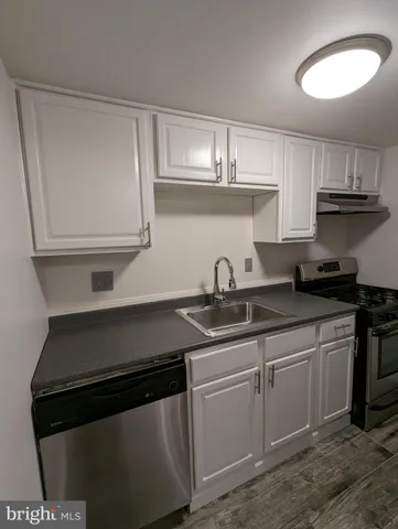 a kitchen with granite countertop white cabinets and a stove