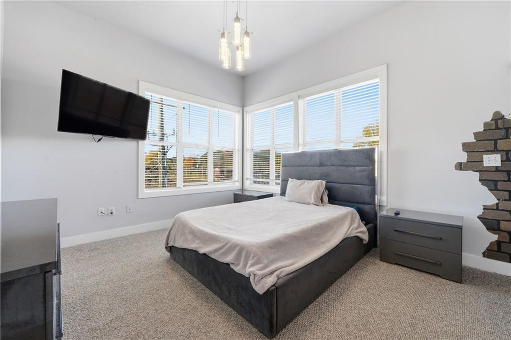 502 Pryor Street Southwest, Unit 328 Atlanta, GA 30312 - Photo 22 of 46 a spacious bedroom with a bed and a flat screen tv