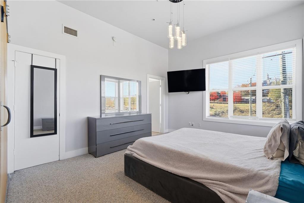 502 Pryor Street Southwest, Unit 328 Atlanta, GA 30312 - Photo 23 of 46 a spacious bedroom with a bed and a flat screen tv