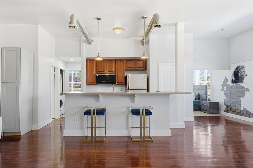 502 Pryor Street Southwest, Unit 328 Atlanta, GA 30312 - Photo 7 of 46 a view of kitchen with stainless steel appliances wooden floor and chair